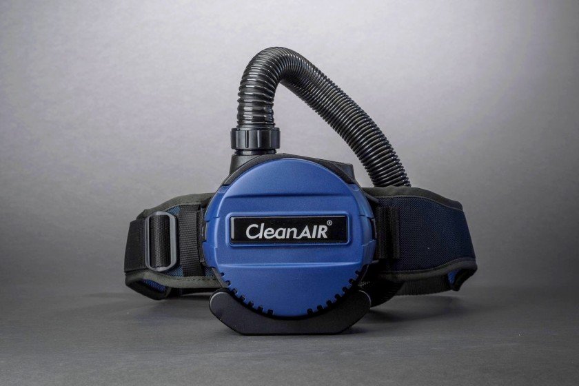 Modrá filtrační jednotka CleanAIR s dýchací hadicí a bederním opaskem pro ochranu dýchacích cest.